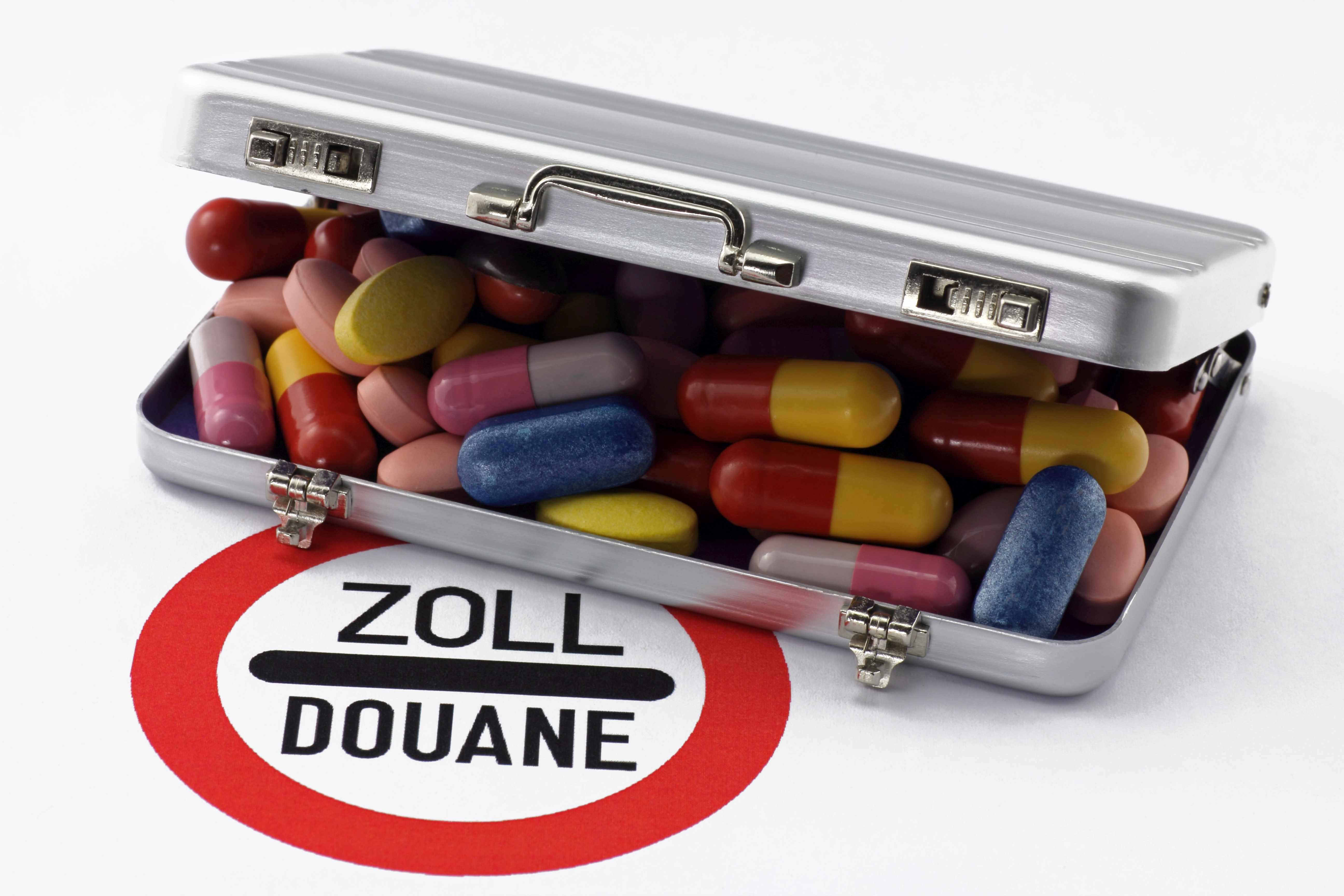 Dose mit bunten Pillen auf Zollschild