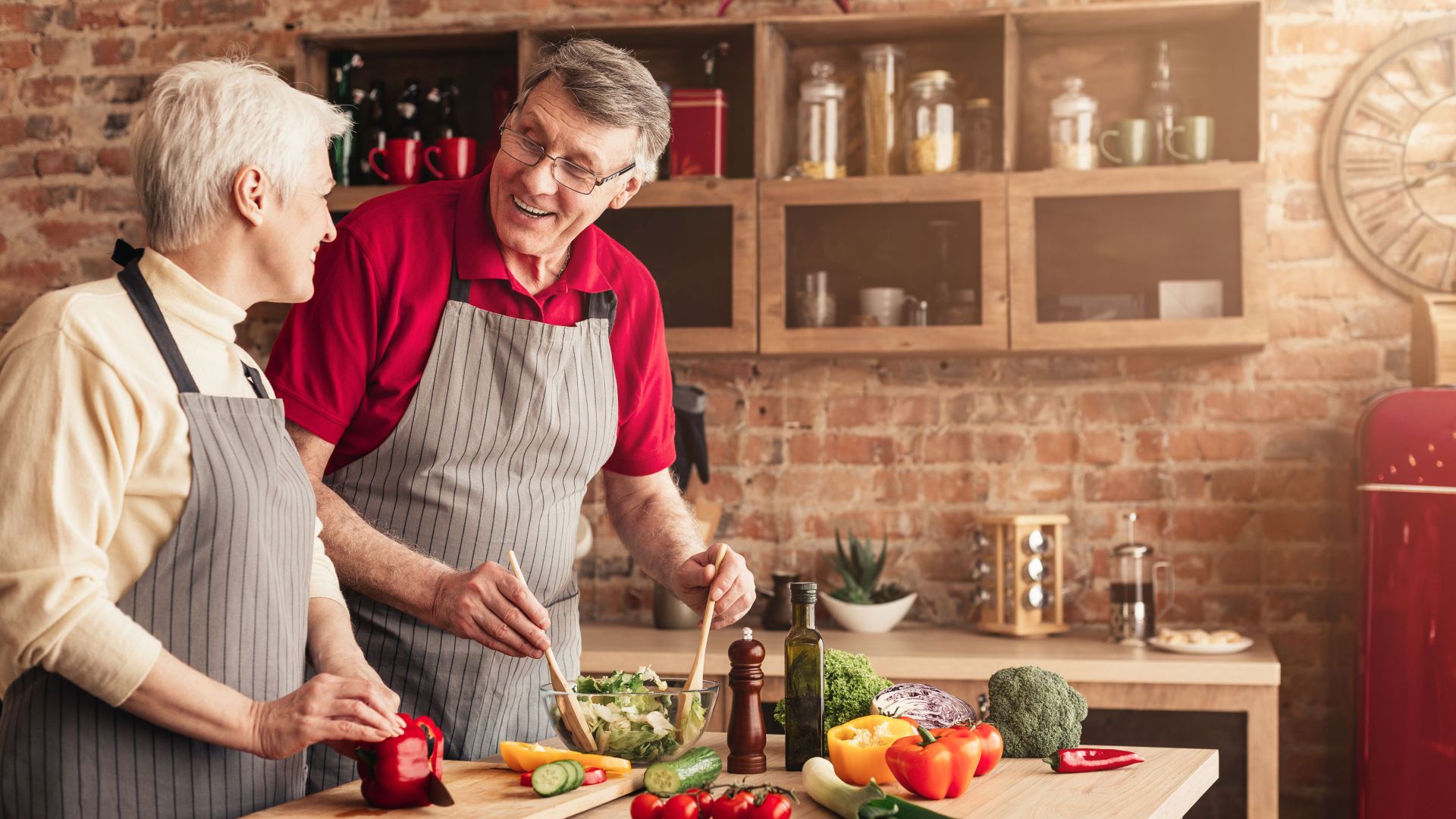 Senior man and woman cooking healthy lunch together in kitchen