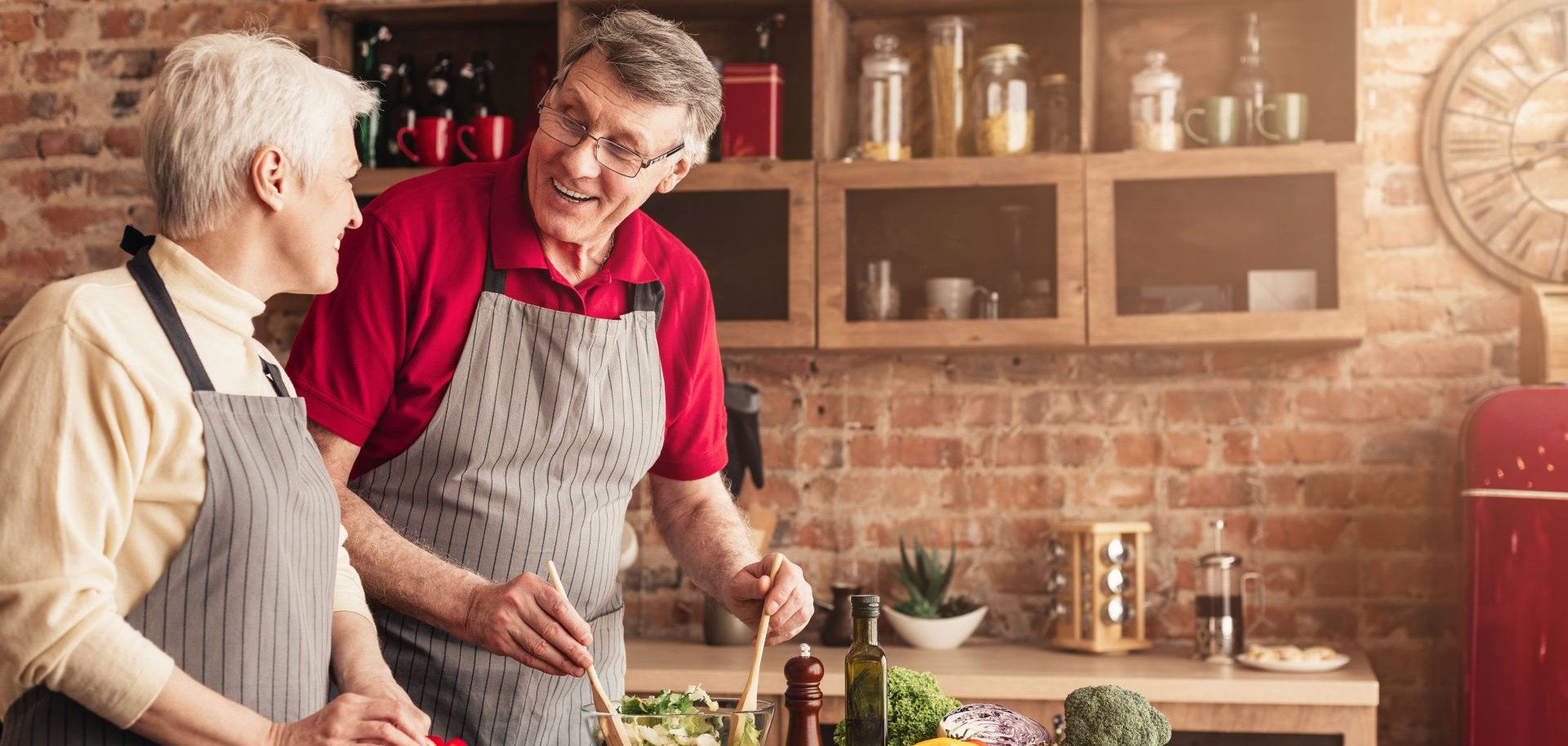 Senior man and woman cooking healthy lunch together in kitchen