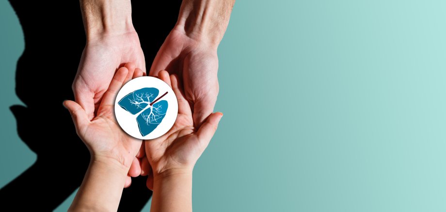 Erwachsenen- und Kinderhände halten Sticker, auf dem Lungen abgebildet sind.