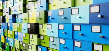 Eine Wand voller Schubladen fpr Akten in verschiedenen blau- und grüntönen 