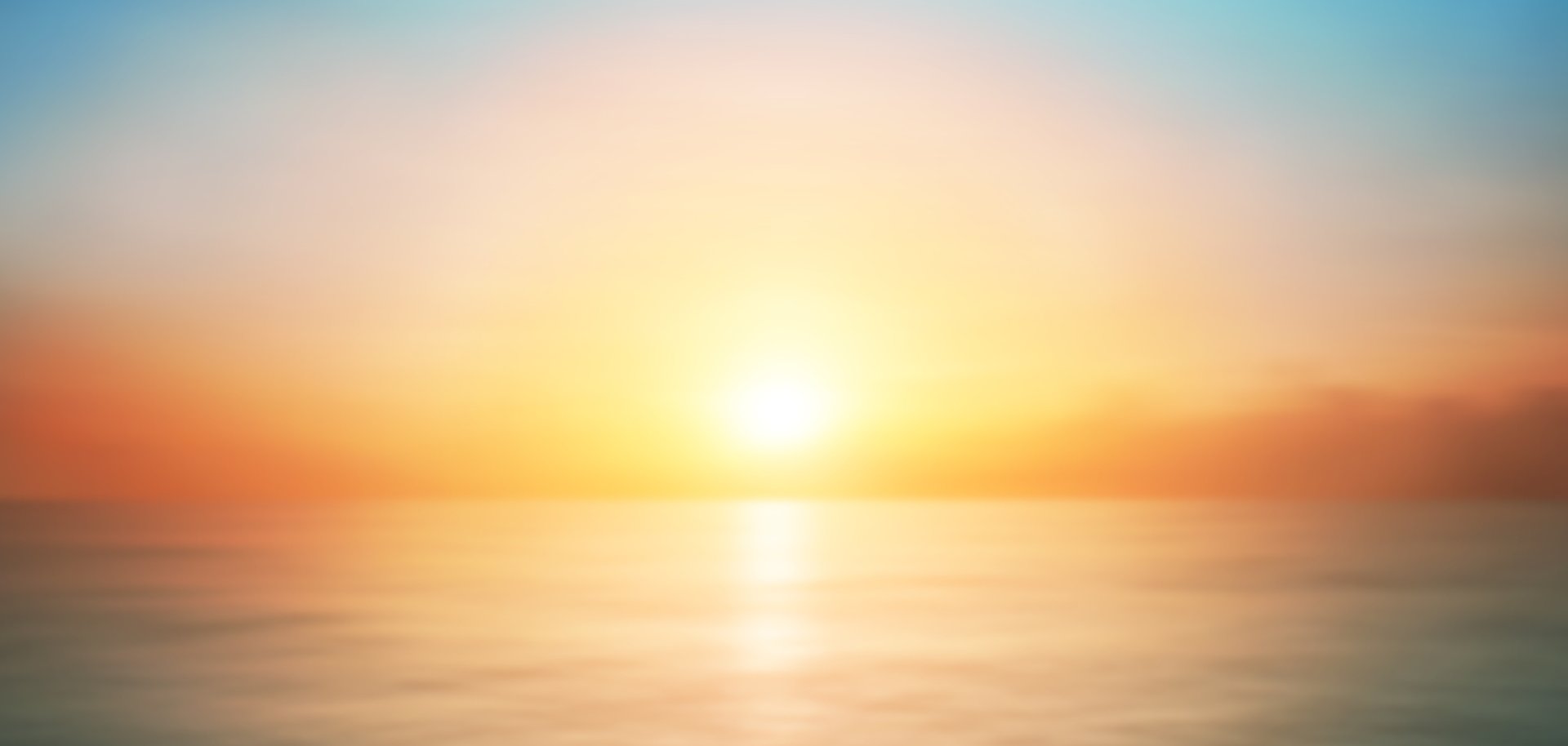 Eine untergehende Sonne hinter einem Meer.