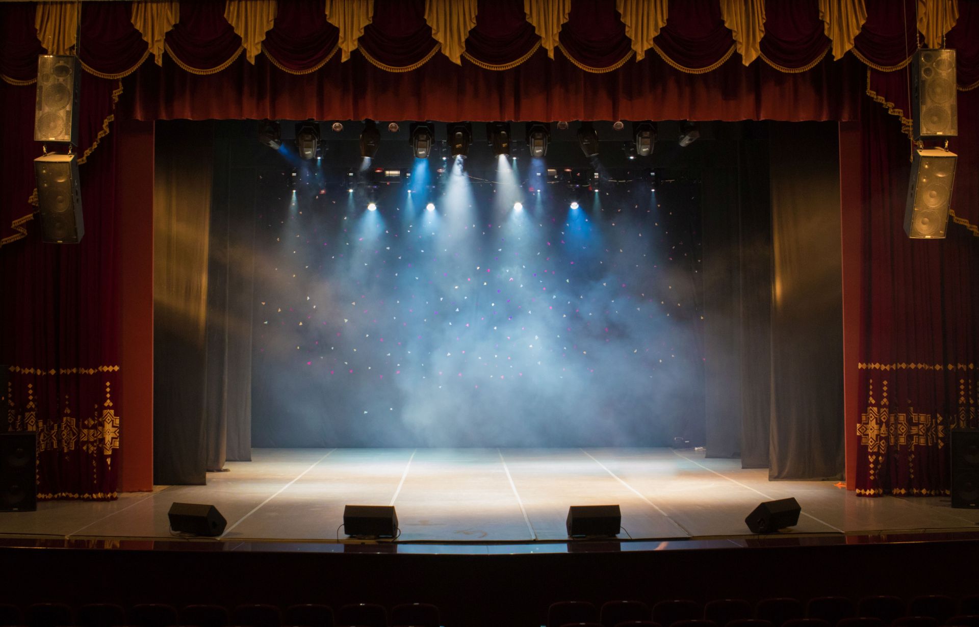The stage of the theater illuminated by spotlights from the audi The stage of the theater illuminated by spotlights from the audi