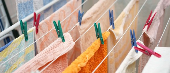 Auf einem Wäscheständer hängen jede Menge Frotteehandtücher zum trocknen.