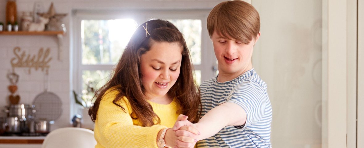 Junge mit Downsyndrome Tanzt mit Mädchen