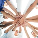 Arbeiter legen Hände aufeinander als Symbol der Teamarbeit