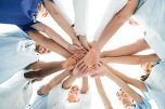 Arbeiter legen Hände aufeinander als Symbol der Teamarbeit