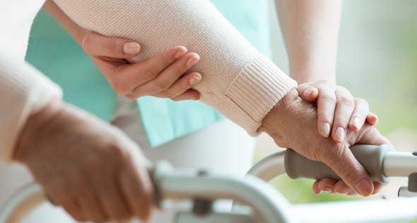 Frau mit Gehhilfe
Nahaufnahme Frau mit Gehhilfe und Pflegerin