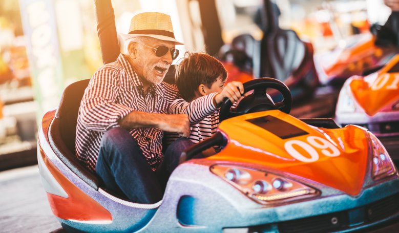 Senior und Enkel fahren Autoscooter Senior fährt mit Enkel Autoscooter
