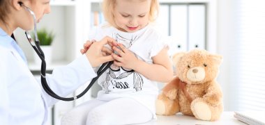 kleines blondes Mädchen beim Besuch bei einer Kinderärztin. 