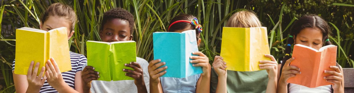 Fünf lesende Kinder sitzen nebeneinander, jedes Kind hält ein andersfarbiges Buch in der Hand