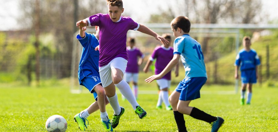 Eine gruppe Jungen spielt Fußball auf einem Fußballfeld.