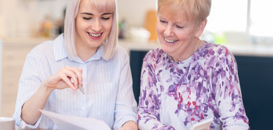 Financial Advisor Helping Senior Neighbor With Paperwork