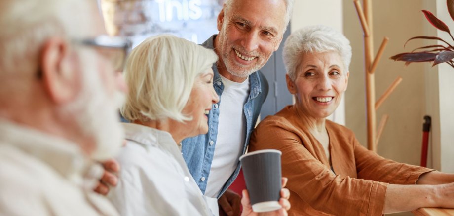 Joyful old friends spending time together in cafe