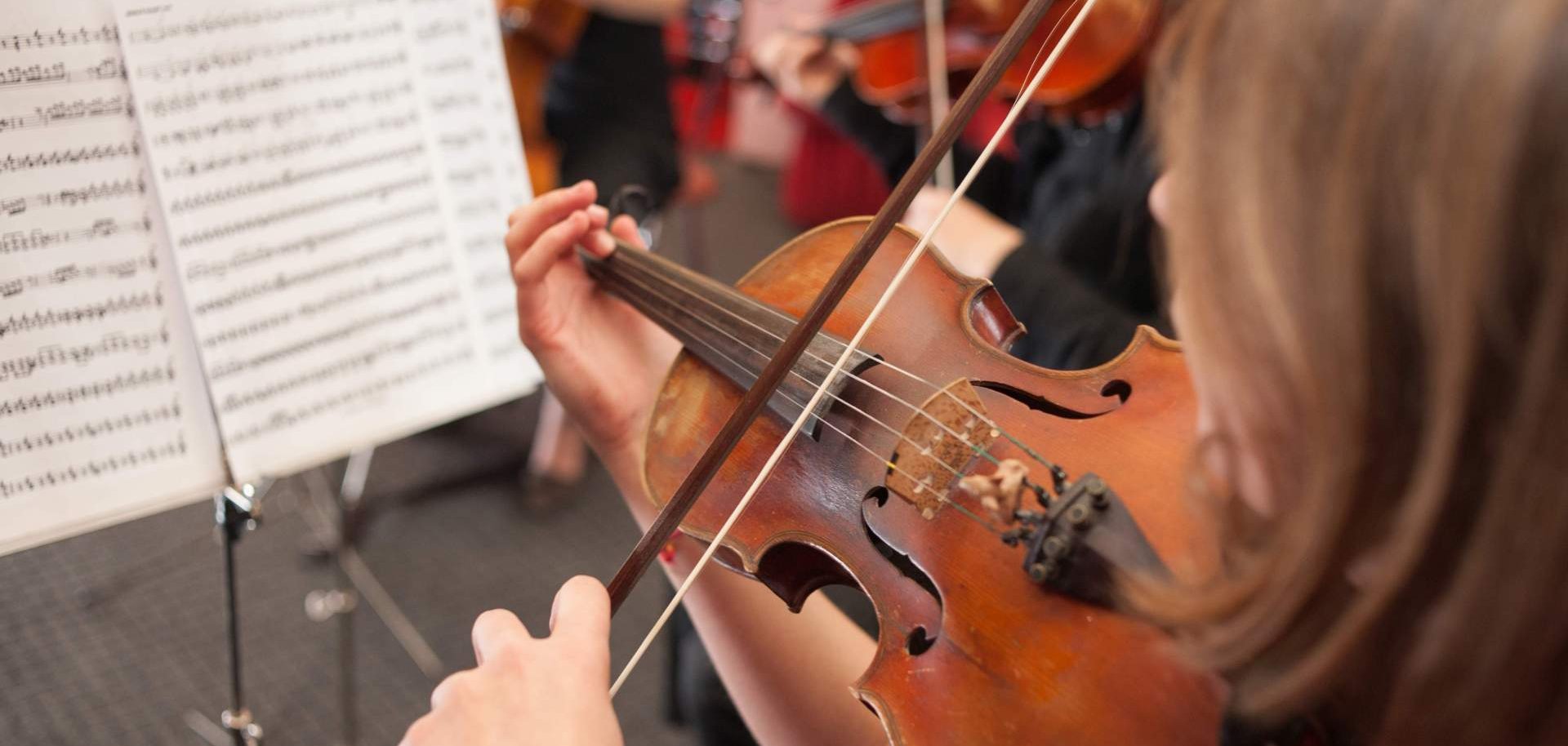 Ein Mädchen spielt auf einer Geige.