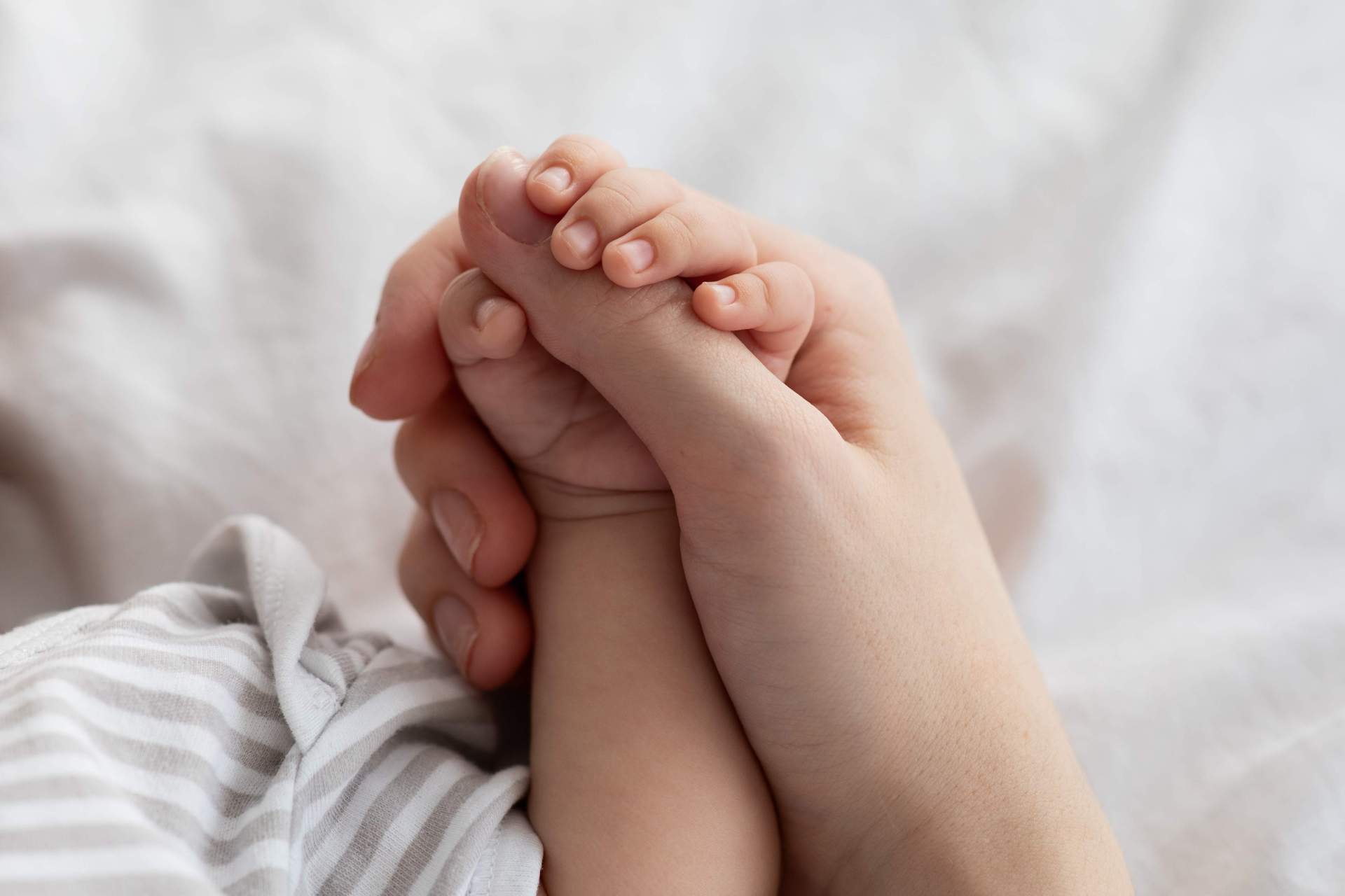 Mother's Protection. Closeup Of Unrecognizable Mom Holding Tiny Hand Of Newborn Baby