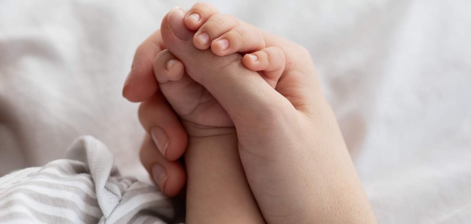 Mother's Protection. Closeup Of Unrecognizable Mom Holding Tiny Hand Of Newborn Baby Mother's Protection. Closeup Of Unrecognizable Mom Holding Tiny Hand Of Newborn Baby