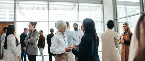 Diverse professionals networking at a business event in a modern office building