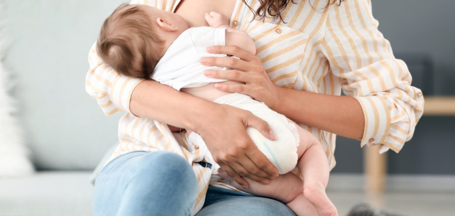 Young woman breastfeeding her baby at home Young woman breastfeeding her baby at home
