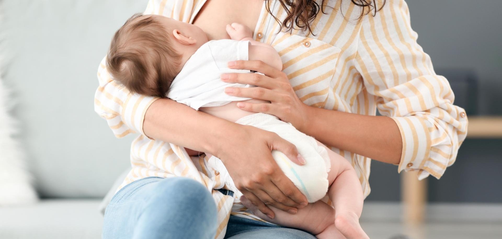 Eine junge Frau stillt ihr Baby.