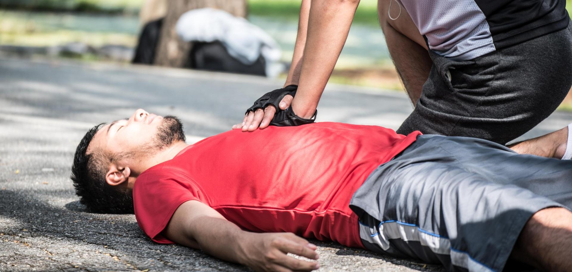 Ein Jogger reanimiert einen am Boden liegenden Mann.