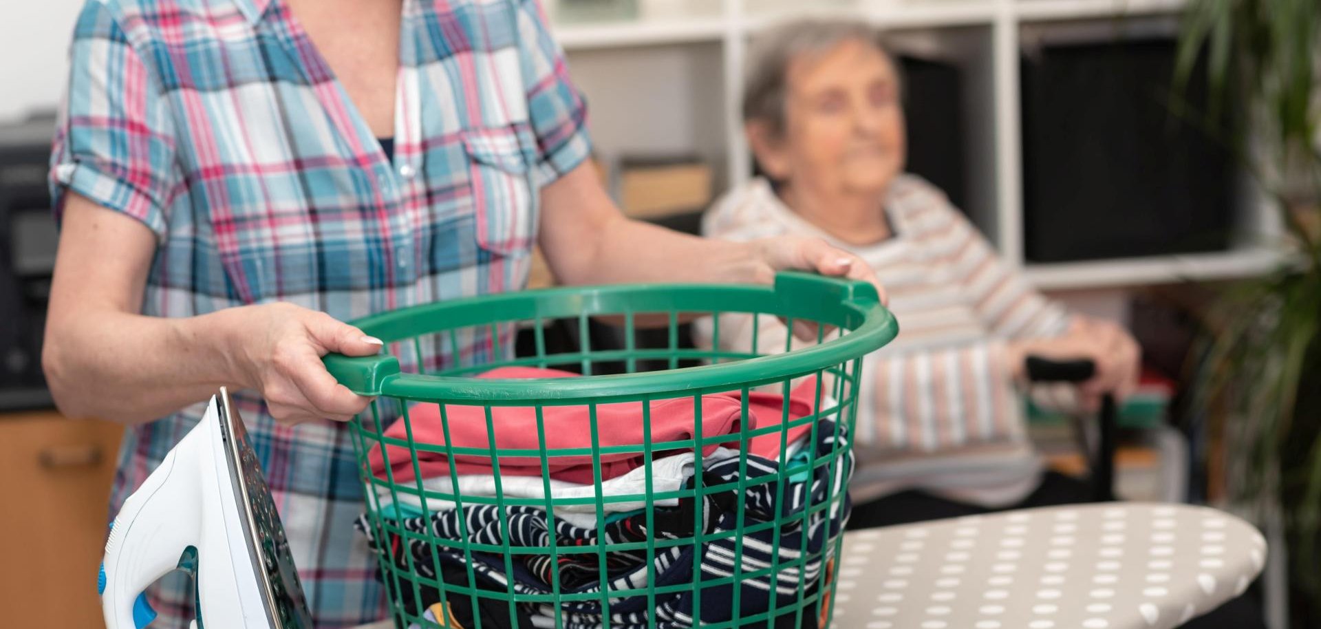Eine Frau hilft einer Seniorin mit der Wäsche.