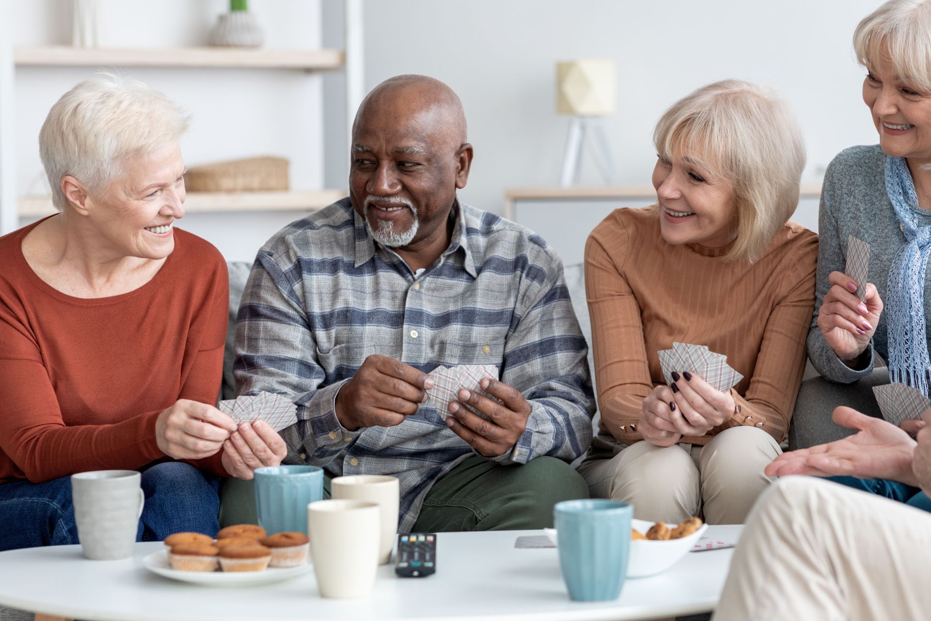 International group of cheerful elderly people chilling together, playing cards