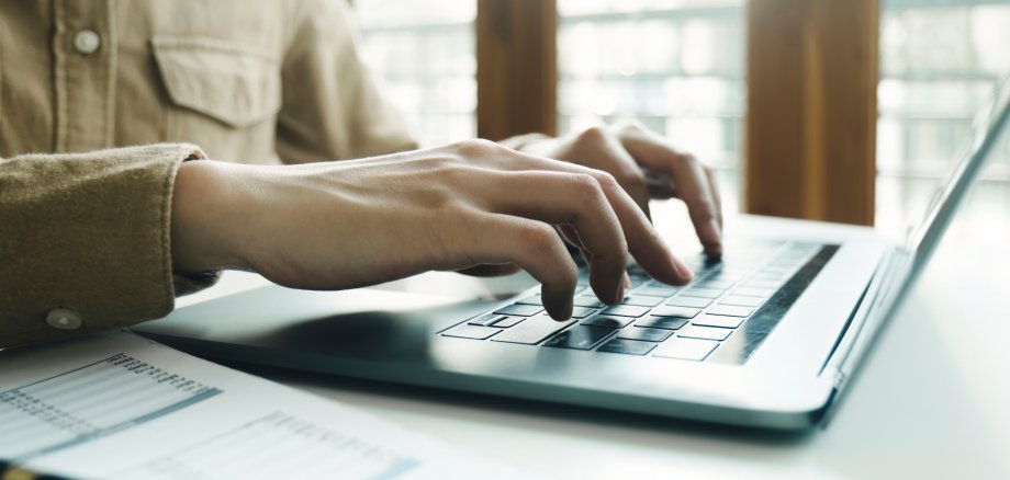 334 - Digitalleistung LEB Nahaufnahme eines Paares Hände, das am Laptop tippt.