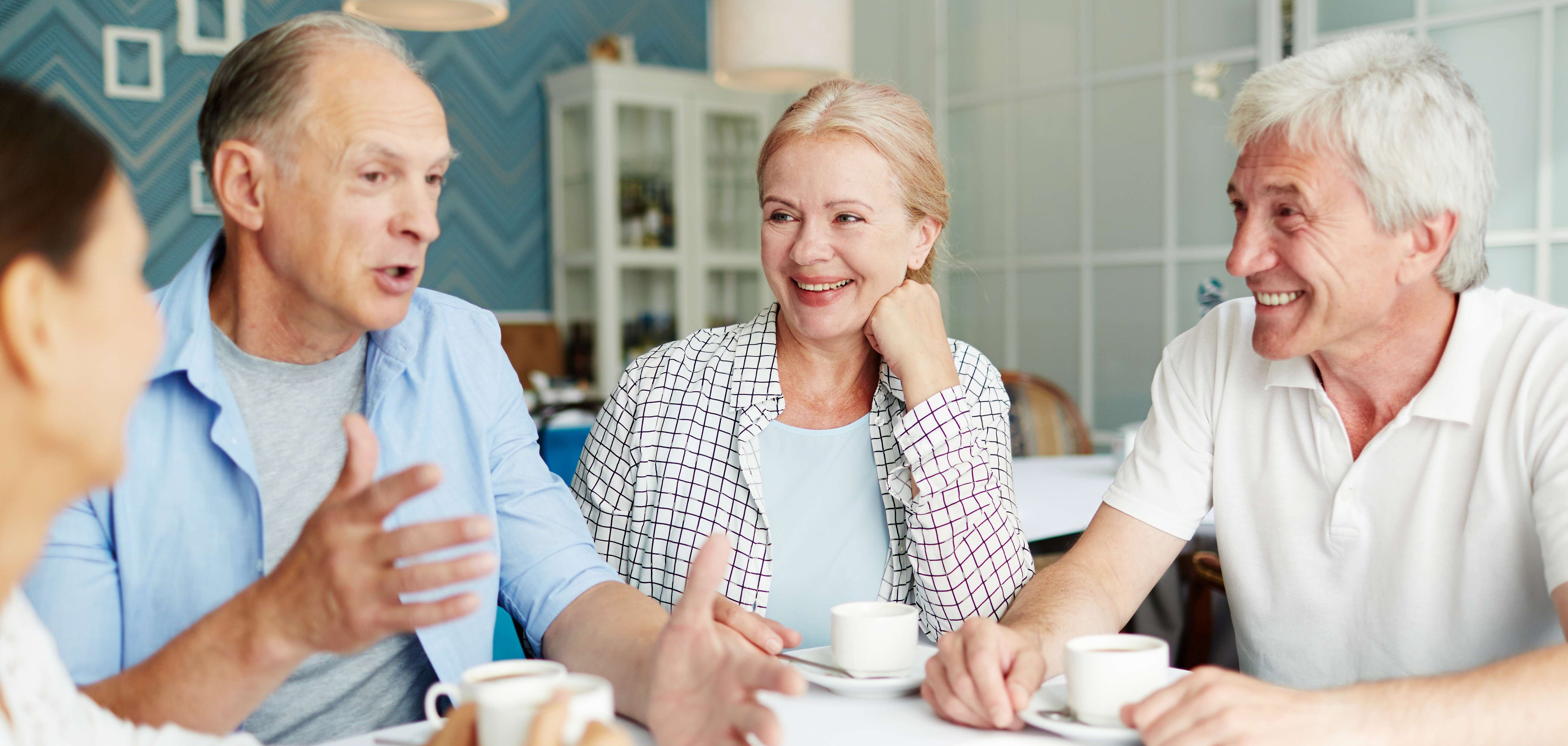 Seniorinnen und Senioren unterhalten sich bei einer Tasse Kaffee
