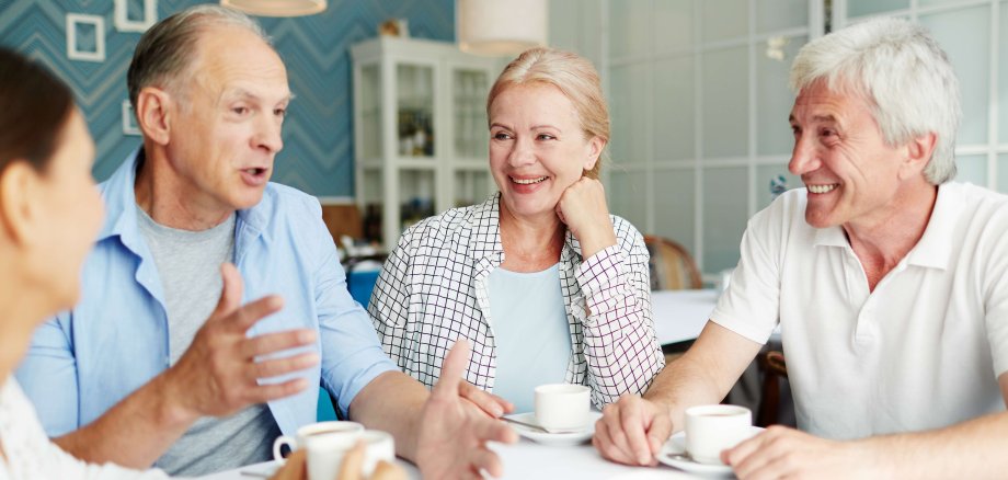 Seniorinnen und Senioren unterhalten sich bei einer Tasse Kaffee