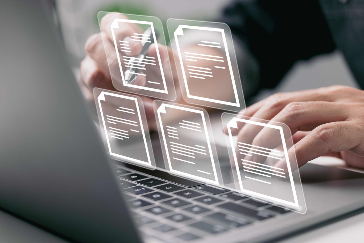 Digitales Arbeiten Hände, die einen Laptop bedienen, dabei sind in der Luft weiße Icons elektronischer Dokumente zu sehen.