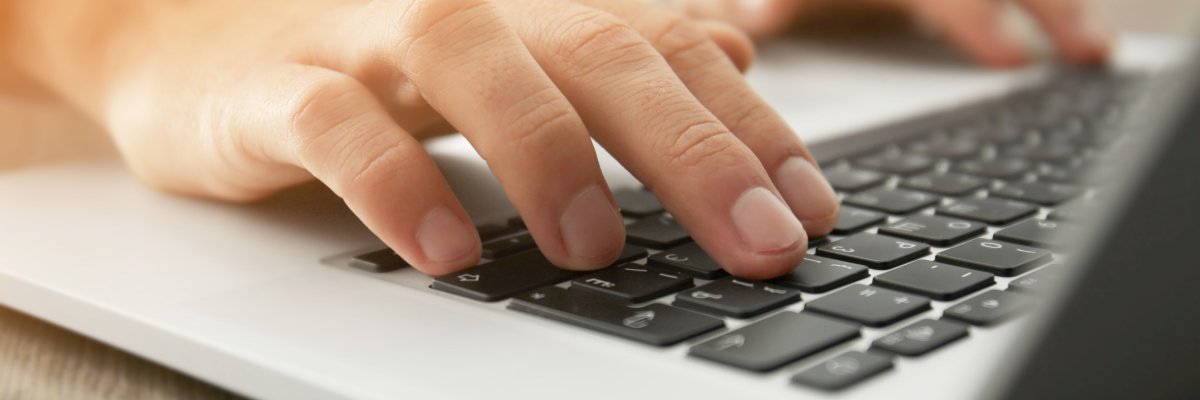 Nahaufnahme zweier Hände, die an einem Laptop arbeiten