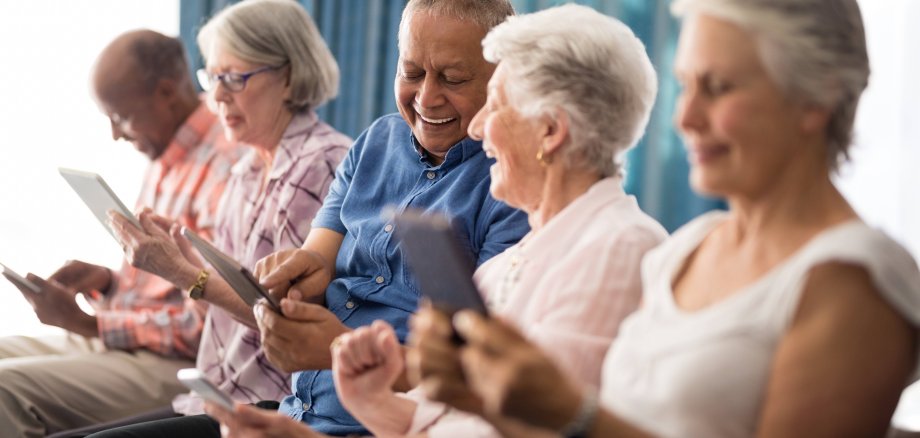 Senioren mit Smartphone besprechen sich
