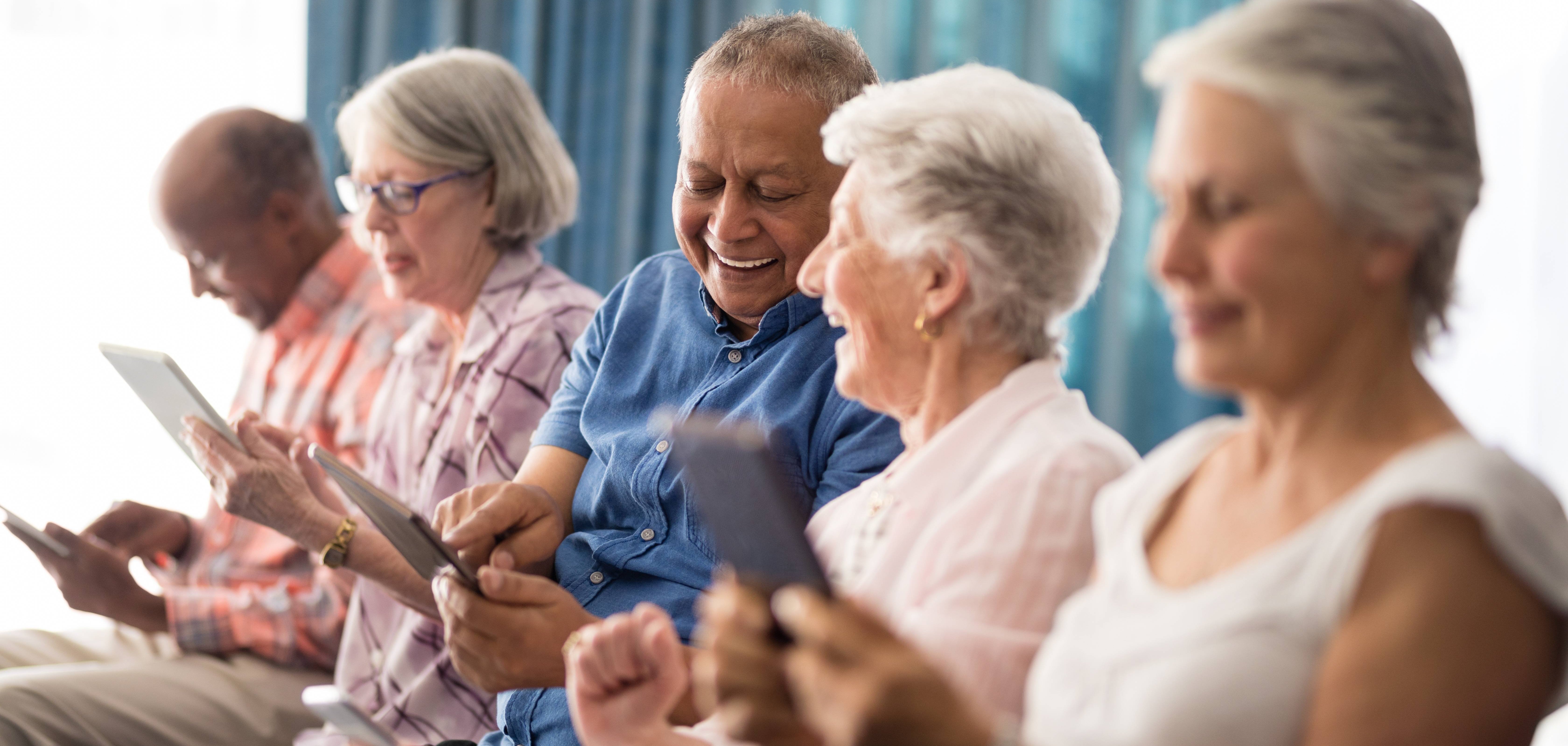 Senioren mit Smartphone besprechen sich