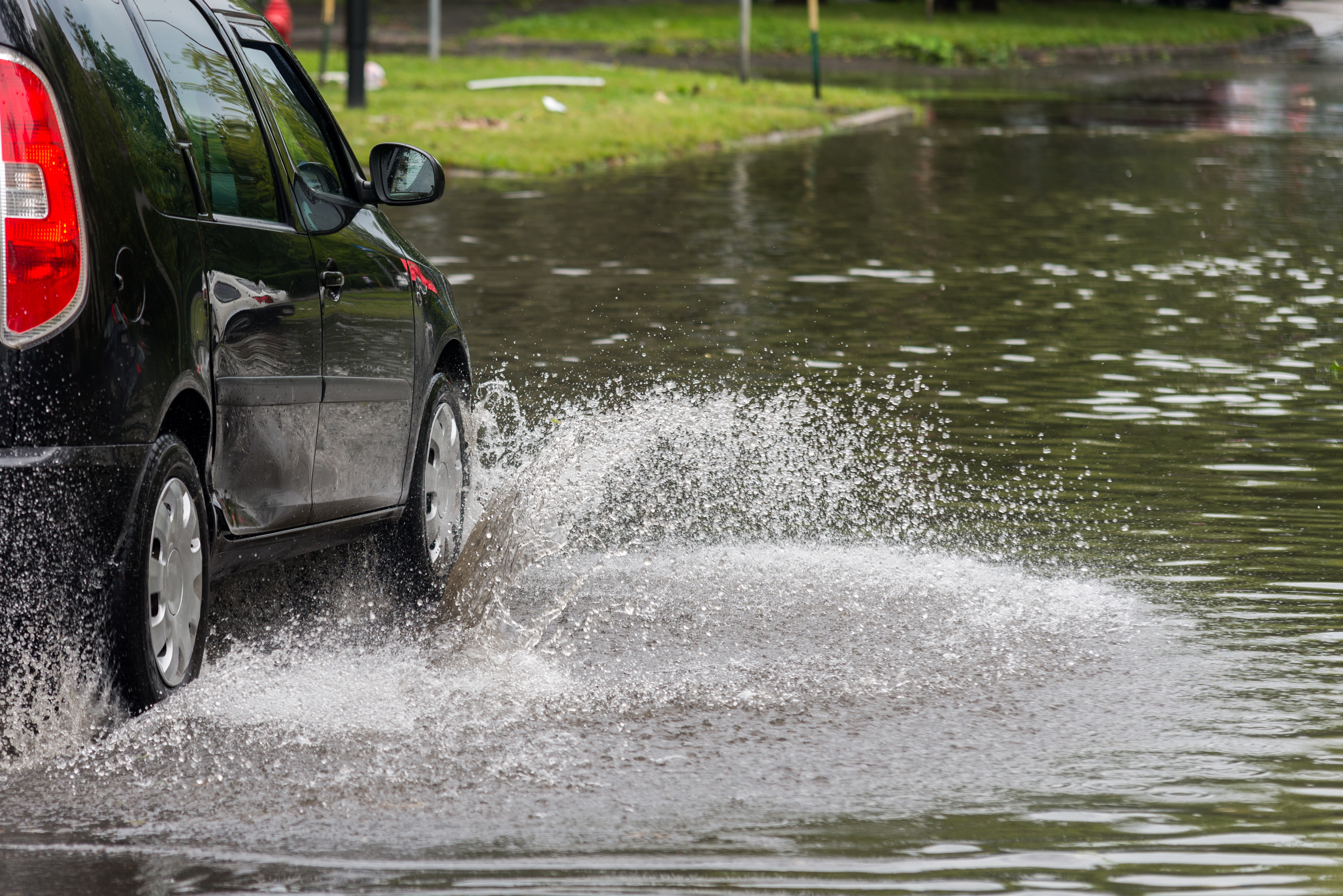 Vortrag am 28.11. um 19 Uhr in Fürth im Rahmen des Klimaforums on Tour 2024. Ein Auto fährt durch eine geflutete Straße.