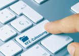 Ein Symbolbild, das einen Finger zeigt, der auf einer Computertatstatur auf den Enter-Knop drückt, auf dem "Kfz-Zulassung" steht