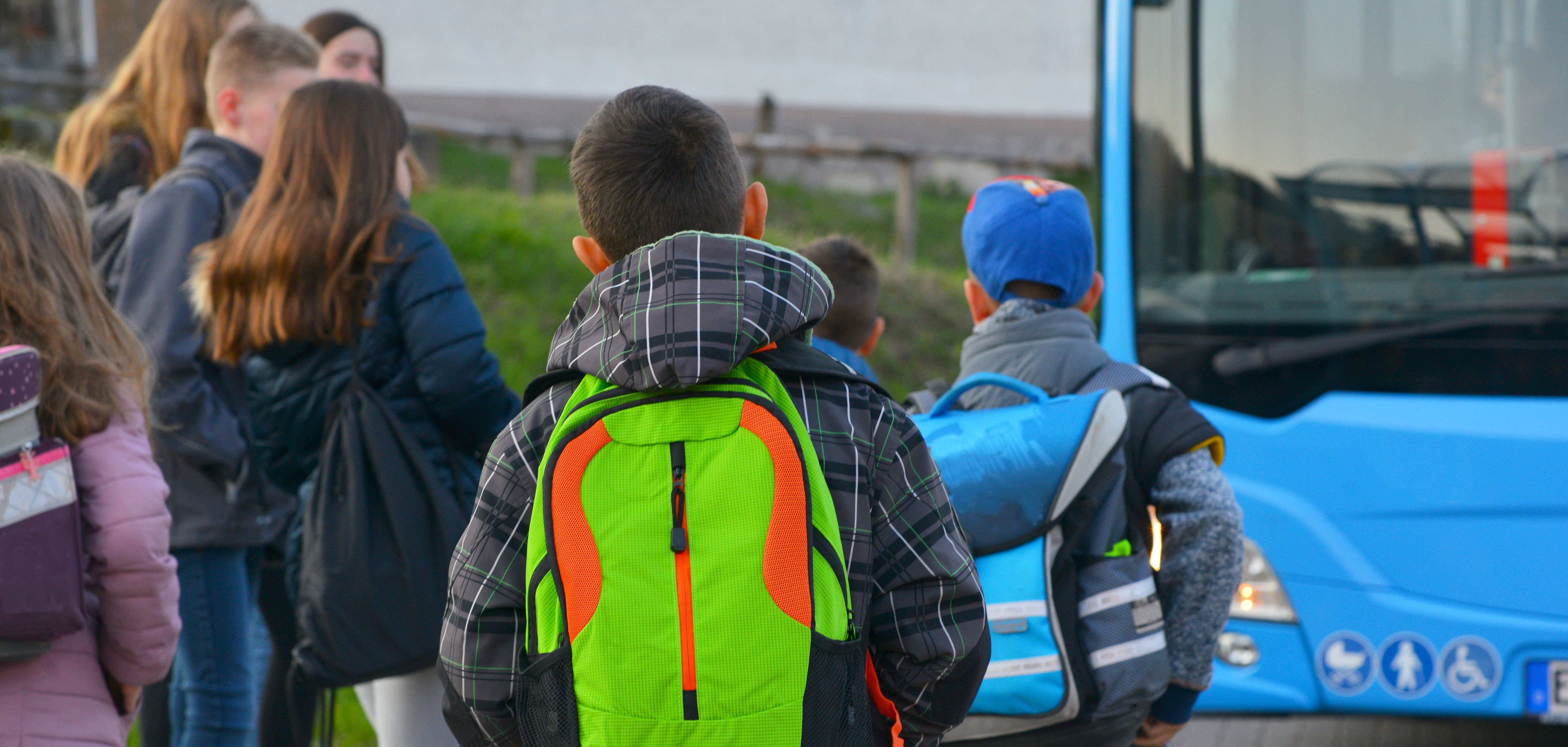 Schüler mit Schulrucksack der Grundschule auf dem morgendlichen Weg zum Schulbus.