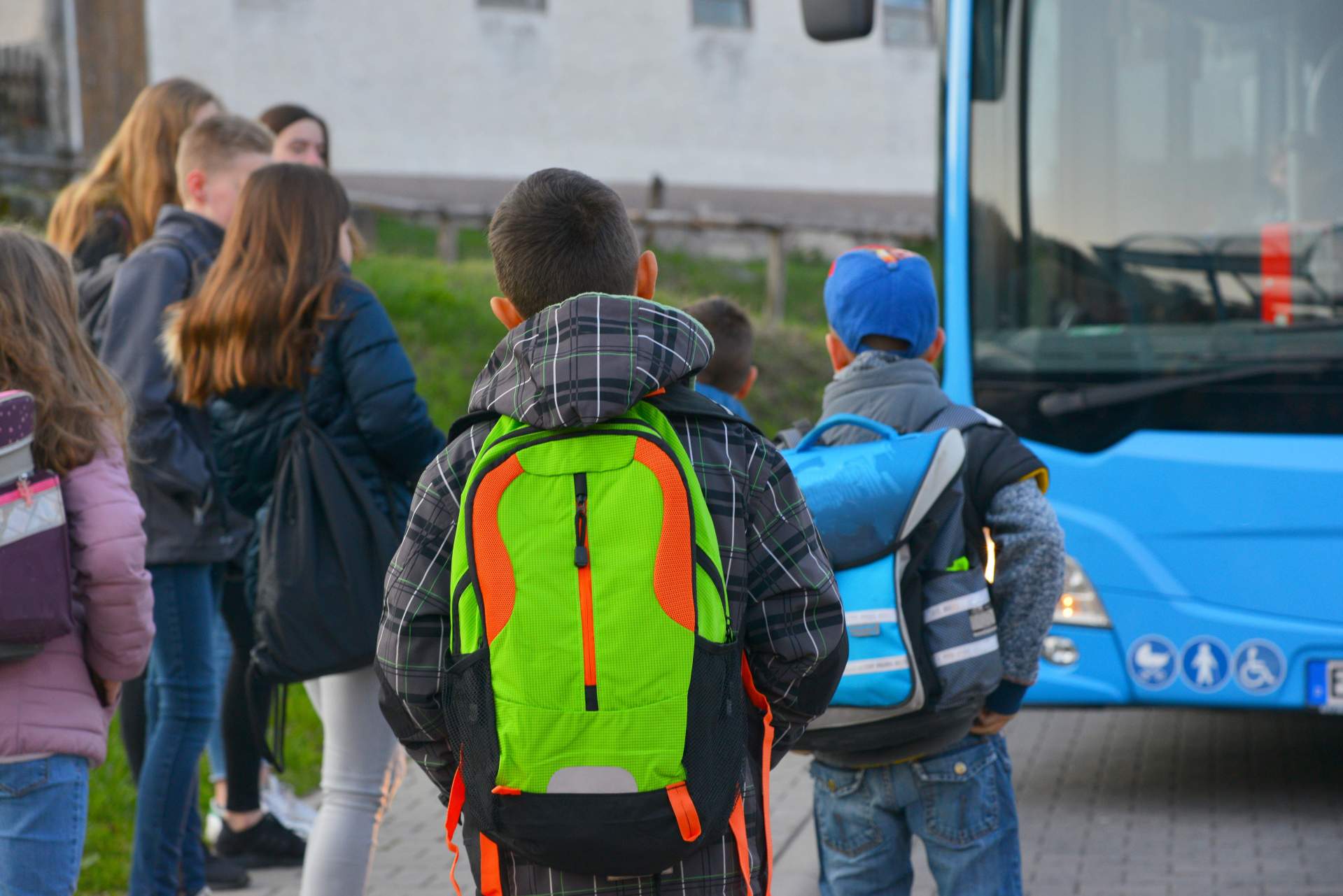 Schüler mit Schulrucksack der Grundschule auf dem morgendlichen Gang zum Bus.