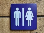 Öffentliche Toilette Ein blaues Schild für eine öffentliche Toilette. Zu sehen sind das Symbol für Mann und das Symbol für Frau.