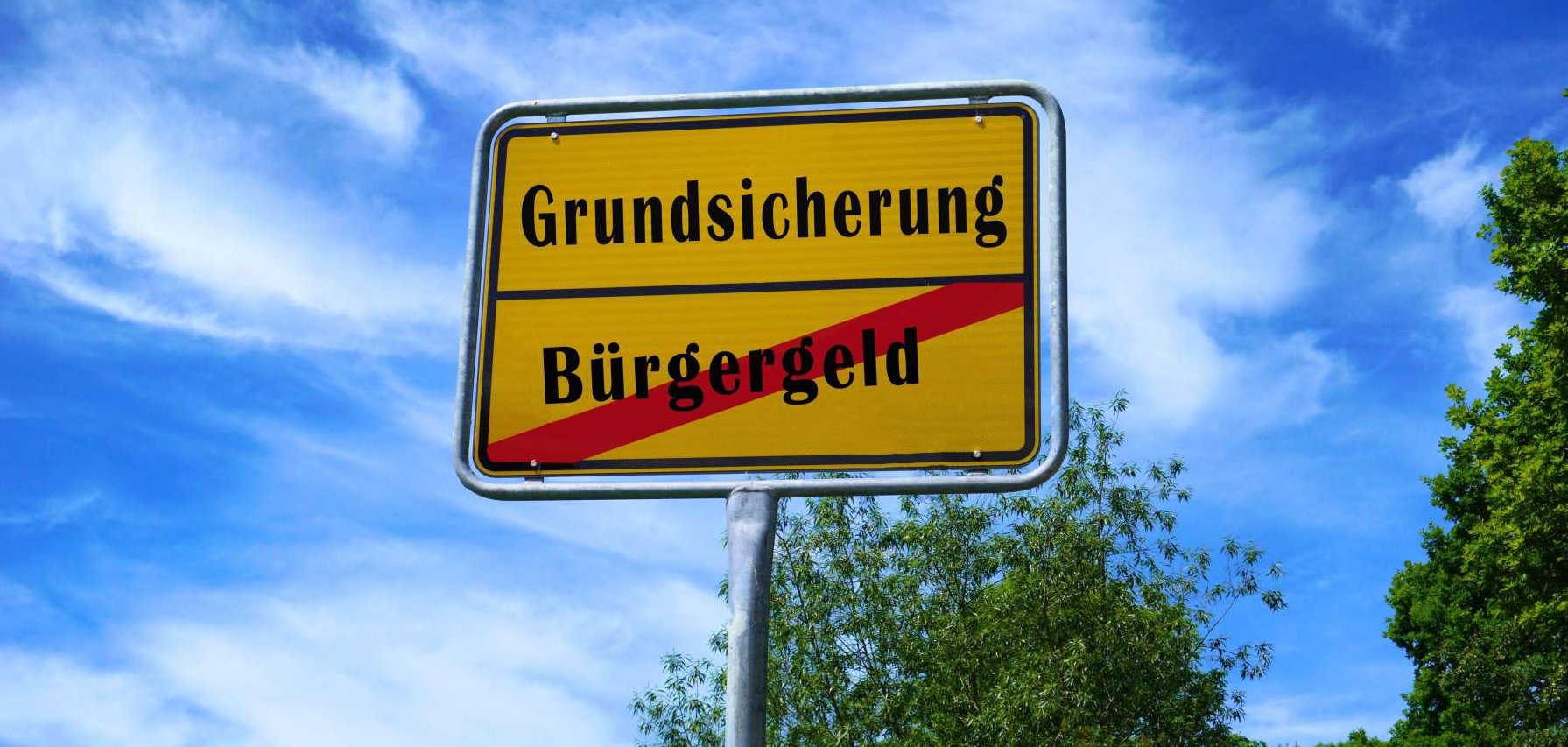 Ein Straßenschild, auf dem das Wort "Bürgergeld" durchgestrichen ist und darüber das Wort "Grundsicherung" steht.