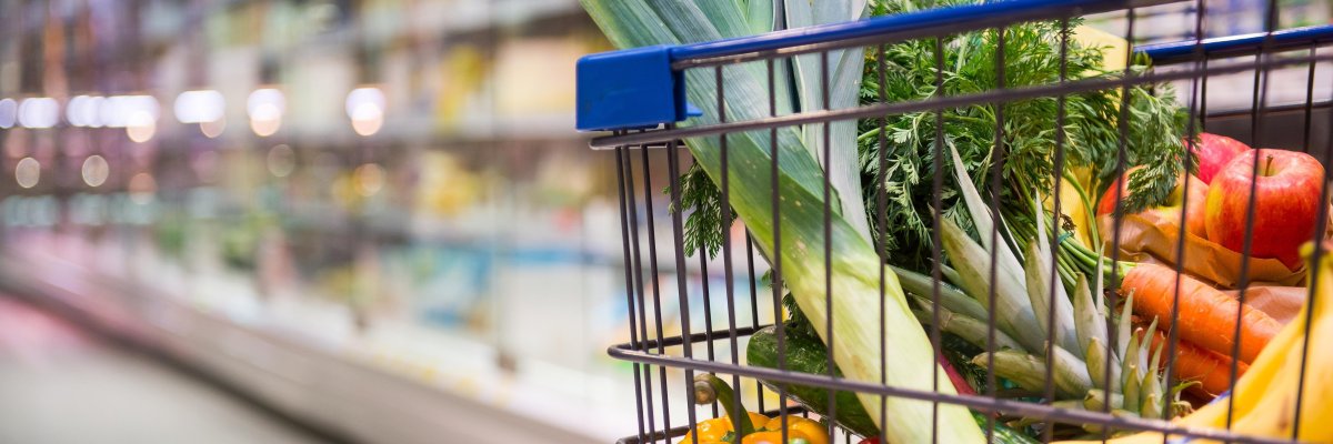 Einkaufswagen mit Obst und Gemüse in einem Supermarkt