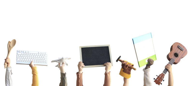 Children are holding books, toys, and a keyboard. Educational concept Hände halten Bücher, Laptop, Gitarre und weitere Gegenstände in die Höhe