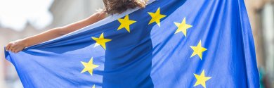 EU Flag. Cute happy girl with the flag of the European Union. Young teenage girl waving with the European Union flag in the city EU Flag. Cute happy girl with the flag of the European Union. Young teenage girl waving with the European Union flag in the city