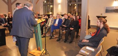 Eröffnungsveranstaltung Austausch Bei der zentralen öffentlichen Eröffnungsveranstaltung tauscht sich der ehemalige litauische Botschafter Ramūnas Misiulis mit den Anwesenden aus.