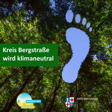 Blauer Himmel in Form eines Fußabdrucks zwischen grünen Baumkronen. An der linken Bildseite befindet sich ein grüner Farbkasten, in dem mit weißer Schrift "Kreis Bergstraße wird klimaneutral" steht. Am unteren Bildrand sind zudem das Logo des Kreises Bergstraße und des Klimaschutzkonzepts zu sehen.