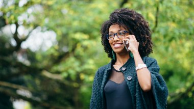 Happy black woman during a mobile phone call in autumn