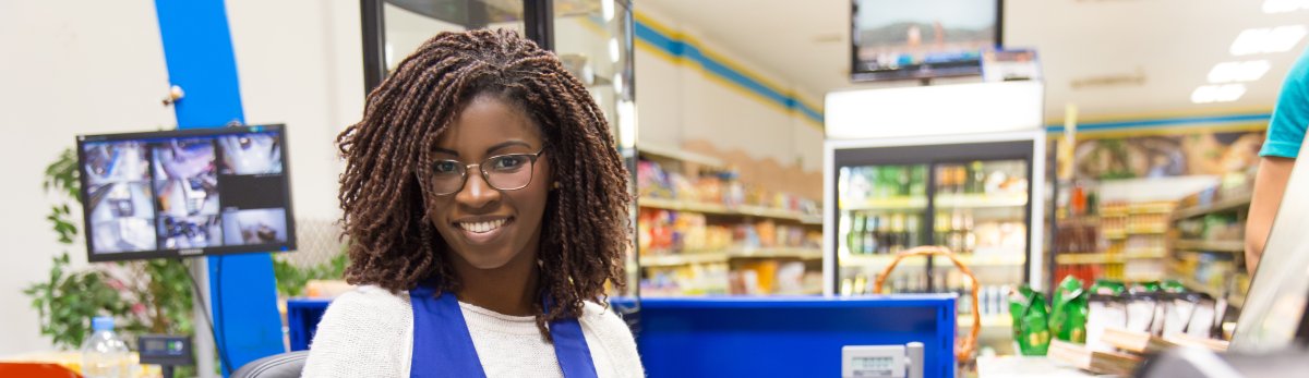 Happy positive female cashier working in grocery store
