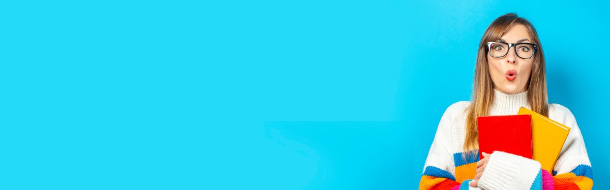 Young woman smiles and holds books in her hands on a blue background. Concept of education, college, session, exam. Banner