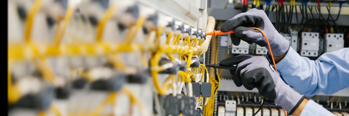 Electrical engineers test electrical installations and wiring on protective relays, measuring them with a multimeter.