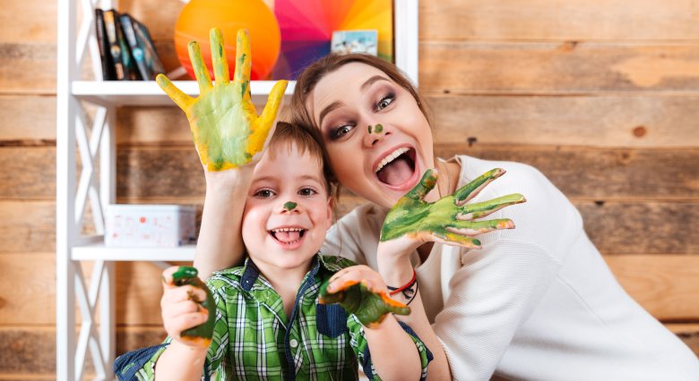 Cheerful mother and son with painted hands having fun together